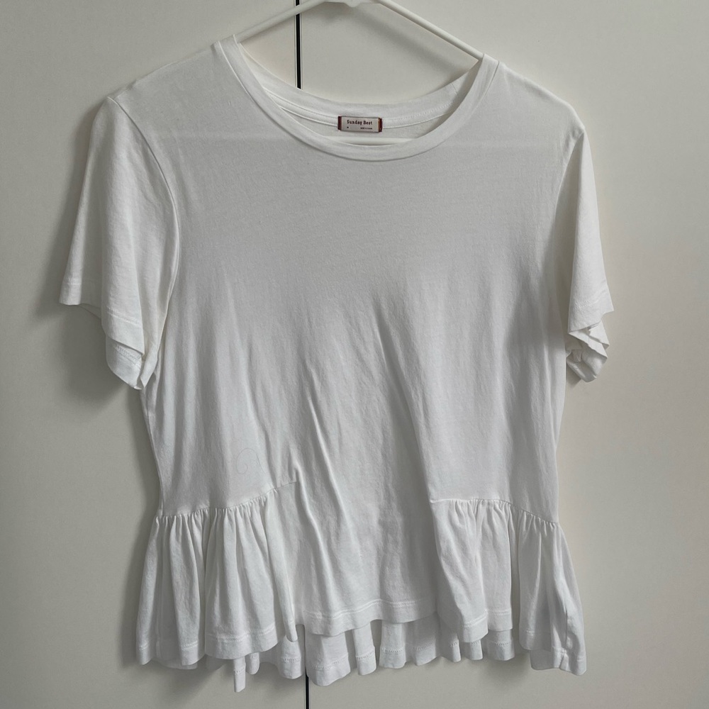 White cotton tshirt with ruffle on bottom.